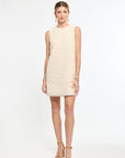 Woman wearing a beige dress on a white background