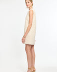 Woman wearing a cream dress on a white background