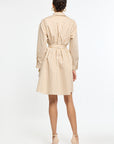 Woman wearing a beige and white striped dress on a white background