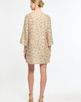 Woman wearing a beige floral dress on a white background