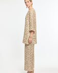 Woman wearing a beige floral outfit on a white background
