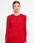 Woman with red v-neck sweater on.