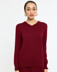 Woman wearing a burgundy sweater on a white background