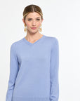 Woman wearing a light blue sweater on a white background