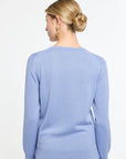 Woman wearing a light blue sweater and skirt set on a white background