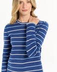 Close-up of a woman wearing a dark blue and white striped outfit on a white background