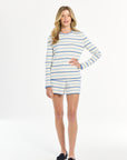 Woman wearing a striped long-sleeve top and shorts on a white background