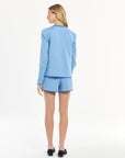 Woman wearing a light blue outfit on a white background
