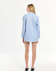 Woman wearing a light blue striped long sleeve blouse on a white background