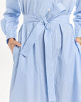 Blue and white striped dress with a tie waist on a plain background