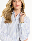 Woman wearing a light blue and white striped shirt on a white backdrop