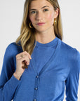 Woman wearing a blue cardigan against a white background