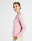 Woman wearing a pink silk crewneck on a white background