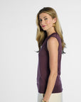 side profile of a woman wearing a purple sleeveless silk top on a white background