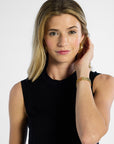 Woman wearing a black sleeveless silk top against a white background