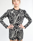 Woman wearing a black and white patterned outfit on a white background