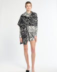Woman wearing a black and white patterned dress on a white background