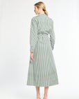 Woman wearing a green and white striped dress on a white background