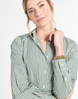 Woman wearing a green and white striped shirt against a plain background