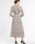 Woman wearing a long, striped dress on a white background