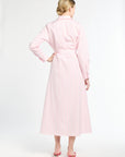 Woman wearing a light pink trench coat on a white background
