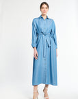 woman modeling a long blue dress with buttons on a white background