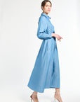 Woman wearing a long blue dress and white heels on a white background