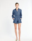 Woman wearing a blue denim jumpsuit on a white background