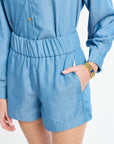 Woman wearing a blue clothing set with a gold bracelet