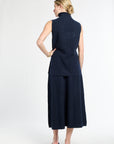 Woman wearing a navy blue sleeveless top and skirt on a white background