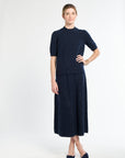 Woman wearing a navy blue dress with a white background