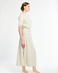 Woman wearing a beige outfit on a white background