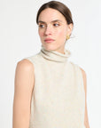 Woman wearing a beige sleeveless sweater on a white background