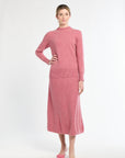 Woman wearing a pink knit outfit on a white background