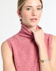 Woman wearing a pink sleeveless top against a white background