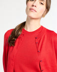 Woman wearing a red cardigan on a white background