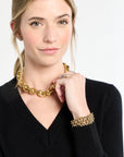 Woman wearing a gold chain necklace and bracelet on a white background
