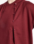 Close-up of a maroon cardigan with buttons on a white background