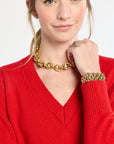Woman wearing a red sweater with gold jewelry on a white background