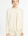 Woman wearing a cream-colored outfit on a white background
