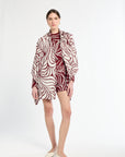 Woman wearing a patterned outfit on a white background