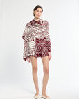 Woman wearing a patterned dress on a white background
