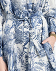 Close-up of a blue and white floral patterned dress with a belt.