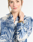 Woman wearing a blue floral patterned blouse against a white background