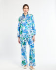 Woman wearing a blue and green floral shirt with matching pants on a white background