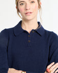 Woman wearing a navy blue sweater with a collar on a white background