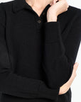 Black sweater worn by a person on a white background