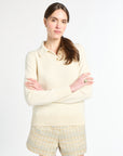 Woman wearing a cream-colored sweater and shorts on a white background