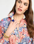 Woman wearing a colorful floral blouse with a white background