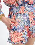 Floral patterned dress with a close-up of a hand in a pocket on a white background